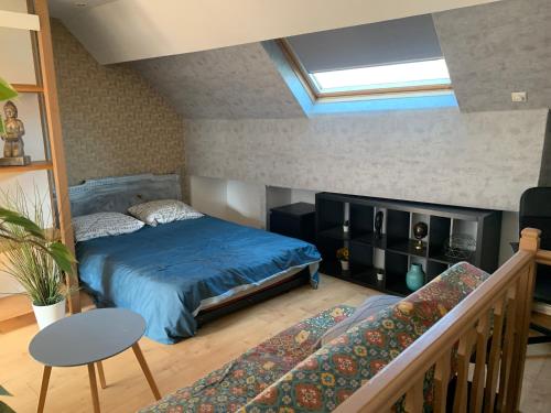 - une chambre avec un lit bleu et un escalier dans l'établissement Petit cocon centre ville, à Gagny