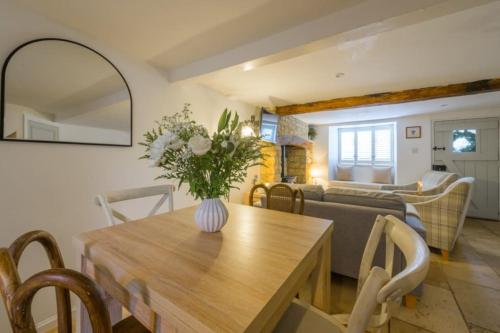 ein Wohnzimmer mit einem Tisch und einer Blumenvase darauf in der Unterkunft Bourton-on-the-Water Lovely 2Bed Cotswold Cottage in Bourton on the Water