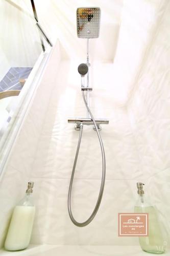 une douche dans une salle de bain blanche avec une bouteille de savon dans l'établissement Oasis de bohème, plage à pied, à Saint-Mandrier-sur-Mer