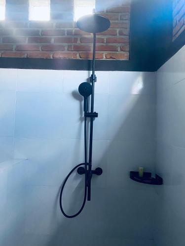 a shower head on a wall in a bathroom at ARISTA Homestay in Tetebatu