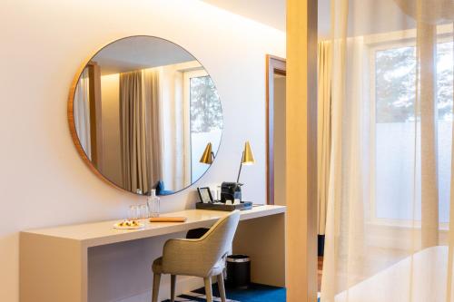 a room with a mirror and a desk with a chair at Palácio do Governador - Lisbon Hotel & Spa in Lisbon