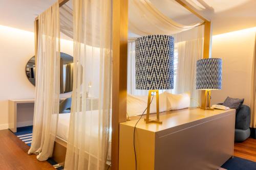 a bedroom with a bed and a desk with a lamp at Palácio do Governador - Lisbon Hotel & Spa in Lisbon