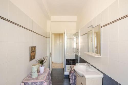 a white bathroom with a sink and a mirror at Casa al Mare - Lido in Terracina