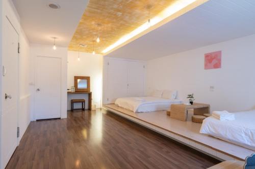 a large white bedroom with two beds and a table at 日日藍旅市區民宿 in Hualien City