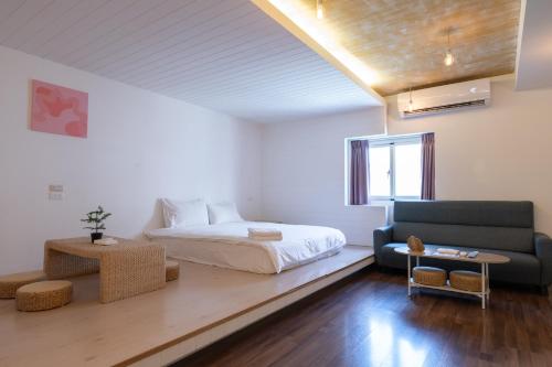 a bedroom with a bed and a couch at 日日藍旅市區民宿 in Hualien City