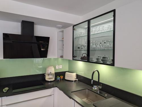 une cuisine avec un évier et un plan de travail dans l'établissement Taylor - 2 pers - Appartement Dinan, à Dinan