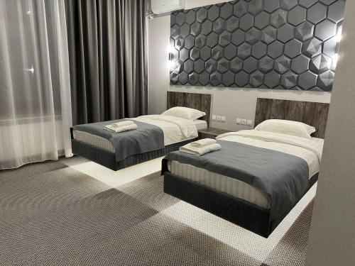 two beds in a hotel room with two beds sidx sidx sidx at Grand Way Hotel in Taraz