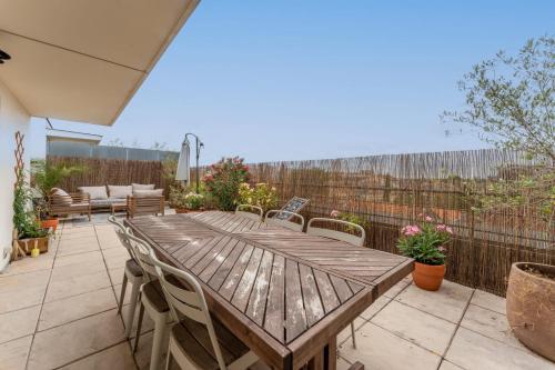 une table et des chaises en bois sur une terrasse dans l'établissement Appartement Duplex Andréia - Welkeys, à Bordeaux