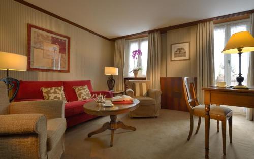 a living room with a red couch and a table at Monte Rosa Boutique Hotel in Zermatt