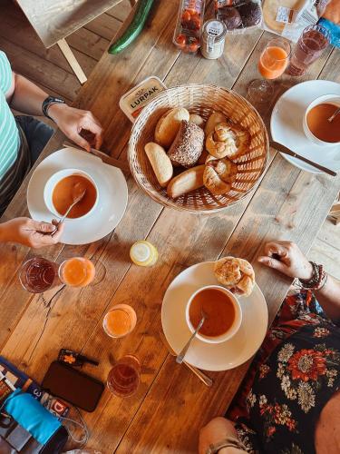people sitting around a wooden table with a basket of food at Vakantiepark Mölke in Zuna