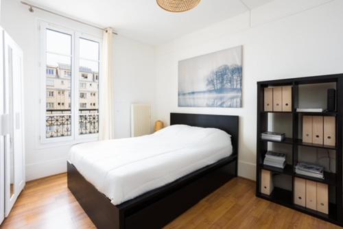 une chambre avec un lit et une étagère dans l'établissement Appartement Grenelle, à Paris