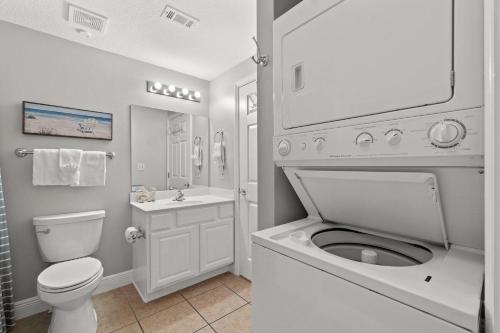 a white bathroom with a toilet and a sink at Ariel Dunes II 1106 in Destin