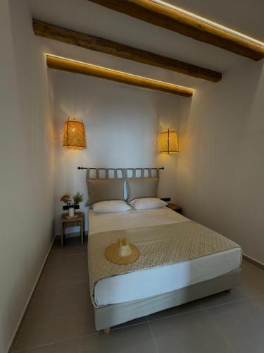 a bedroom with a bed with two lights on the wall at Deos luxury house in Ios Chora