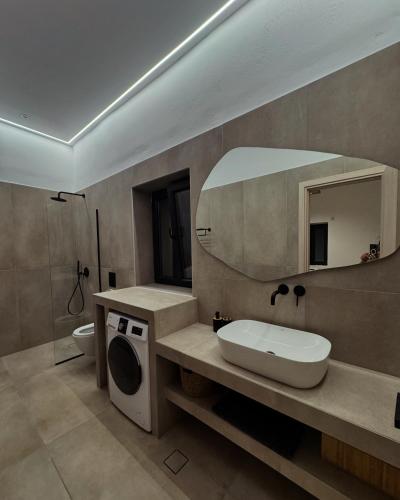 a bathroom with a sink and a mirror at Deos luxury house in Ios Chora