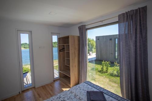a bedroom with a large window with a view of the water at Haus PEAK am See in Zirkow