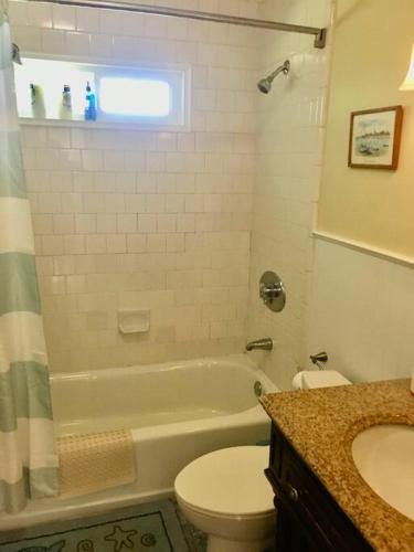 a bathroom with a tub and a toilet and a sink at The Buoys in Gloucester