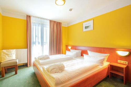a bedroom with two beds with yellow walls at SEETELHOTEL Nautic Usedom Hotel & Spa das Hotel für Wellness & Genuss auf Usedom in Ostseebad Koserow