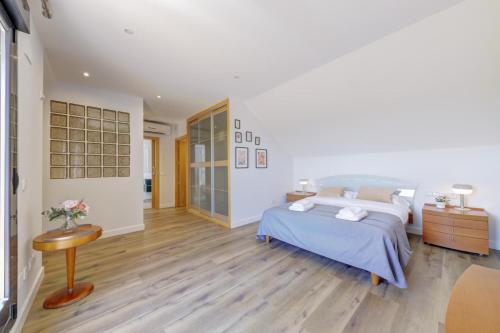 a bedroom with a large bed and a wooden floor at El Palomar in Madrid