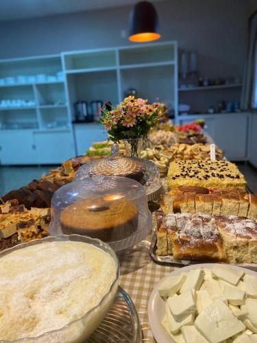 a table full of different types of cakes and pastries at Hotel Rinkao in Cachoeiro de Itapemirim