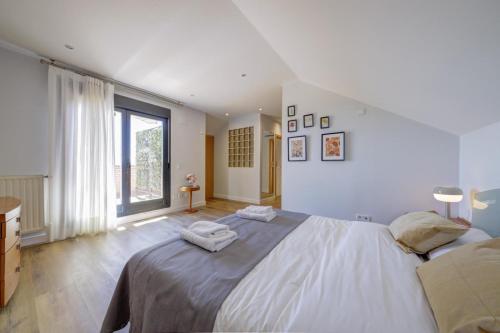a bedroom with a large bed and a large window at El Palomar in Madrid