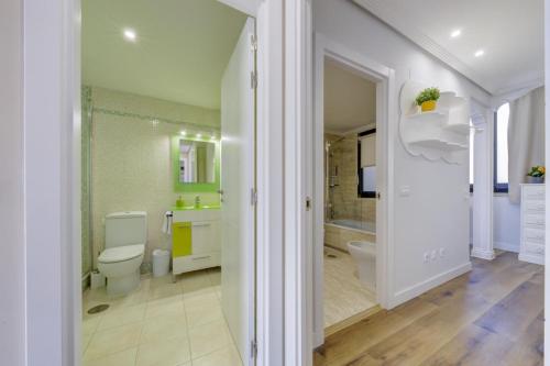 a white bathroom with a toilet and a shower at El Palomar in Madrid