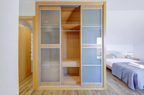 a glass closet in a bedroom with a bed at El Palomar in Madrid