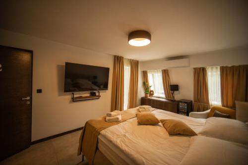a bedroom with a large bed with a television on the wall at Cantina rooms in Hum na Sutli