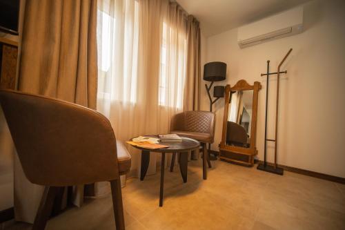 a room with a table and a chair and a mirror at Cantina rooms in Hum na Sutli