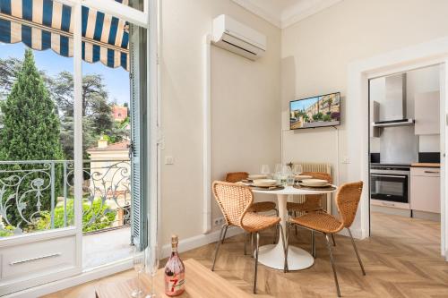 une salle à manger avec une table et des chaises et une fenêtre dans l'établissement MONT FLEURI- Somptueux 2 pièces - Parking - Menton, à Menton