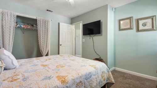 a bedroom with a bed and a flat screen tv at Beach access close to Walmart, Bowling,skating and Game room in Panama City Beach