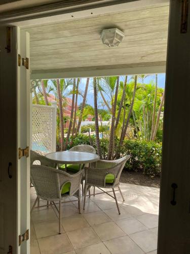 a patio with a table and chairs and trees at Kings Beach Village in Saint Peter