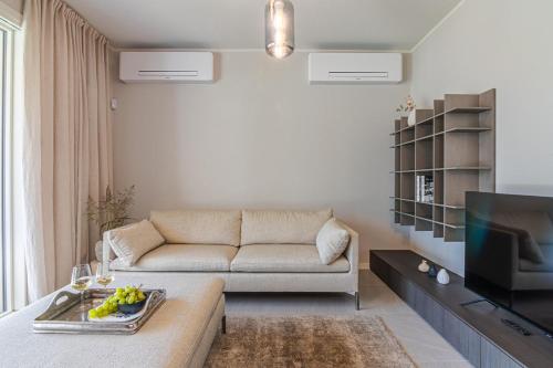 a living room with a couch and a tv at Lago Dorato Luxury Apartments - Lake Como View in Colico
