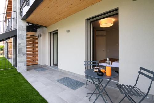 a patio with a table and chairs in a house at Lago Dorato Luxury Apartments - Lake Como View in Colico