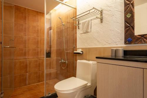 a bathroom with a toilet and a glass shower at 日日藍旅市區民宿 in Hualien City
