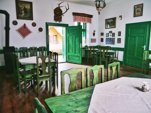 a dining room with green doors and tables and chairs at Panoráma Panzió Torockó in Rimetea