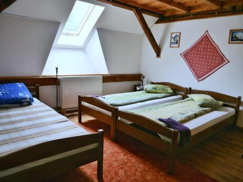 a bedroom with two beds in a attic at Panoráma Panzió Torockó in Rimetea
