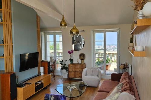 TV a/nebo společenská místnost v ubytování Le toit chic à 15 mn Paris Centre