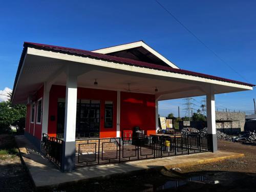 a red and white building with a patio at K-Villa Homestay Tuaran in Kampong Marabahai