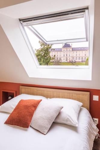 une chambre avec une grande lucarne au-dessus d'un lit dans l'établissement Superbe duplex avec vue, à Caen