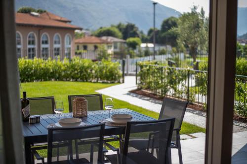 a table with chairs and wine glasses on a patio at Lago Dorato Luxury Apartments - Lake Como View in Colico