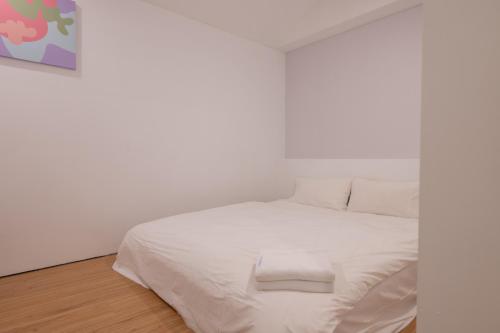 a white bed in a white room with white walls at 日日藍旅市區民宿 in Hualien City
