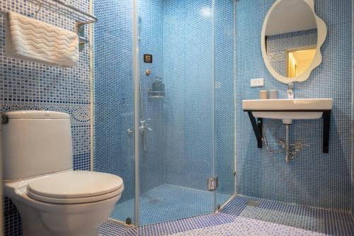 a bathroom with a shower and a toilet and a sink at 日日藍旅市區民宿 in Hualien City
