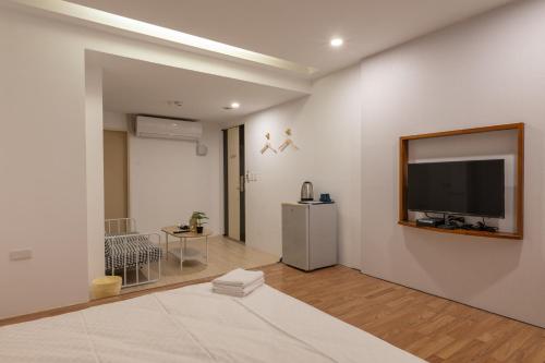 a living room with a flat screen tv on the wall at 日日藍旅市區民宿 in Hualien City