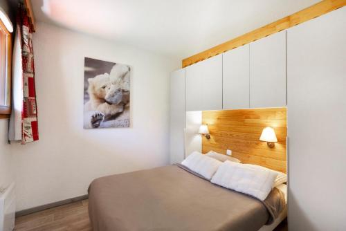 a bedroom with a bed and a picture of a teddy bear at A3 405 Appart au pied des pistes in Saint-François-Longchamp