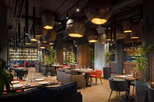 a restaurant with tables and chairs and pendant lights at Apartel Skhidnytsya in Skhidnitsa