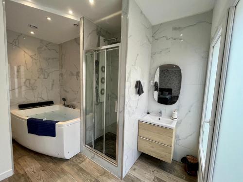 a bathroom with a shower and a tub and a sink at Appartement Romantique - 044 in Rouen