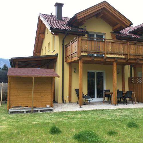 a house with a deck and a table and chairs at Ferienhaus Seltschach 193 in Arnoldstein