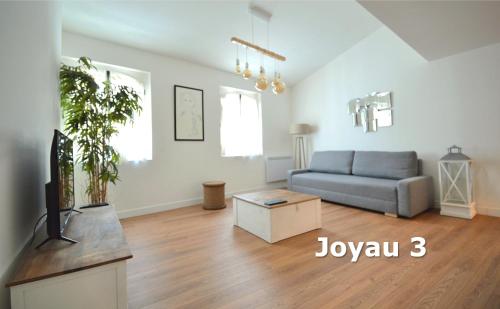 a living room with a couch and a tv at Les Appartements du Vieux Port in Marseille
