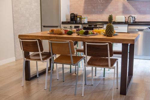 a kitchen with a wooden table with chairs and fruit on it at La Granja Villa in La Granja de San Ildefonso
