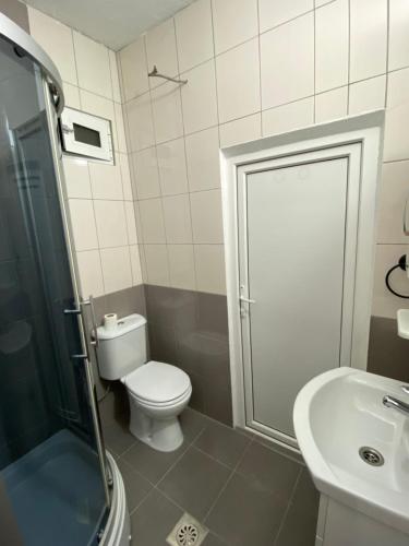 un bagno con WC, lavandino e doccia di Lake City Apartment a Struga